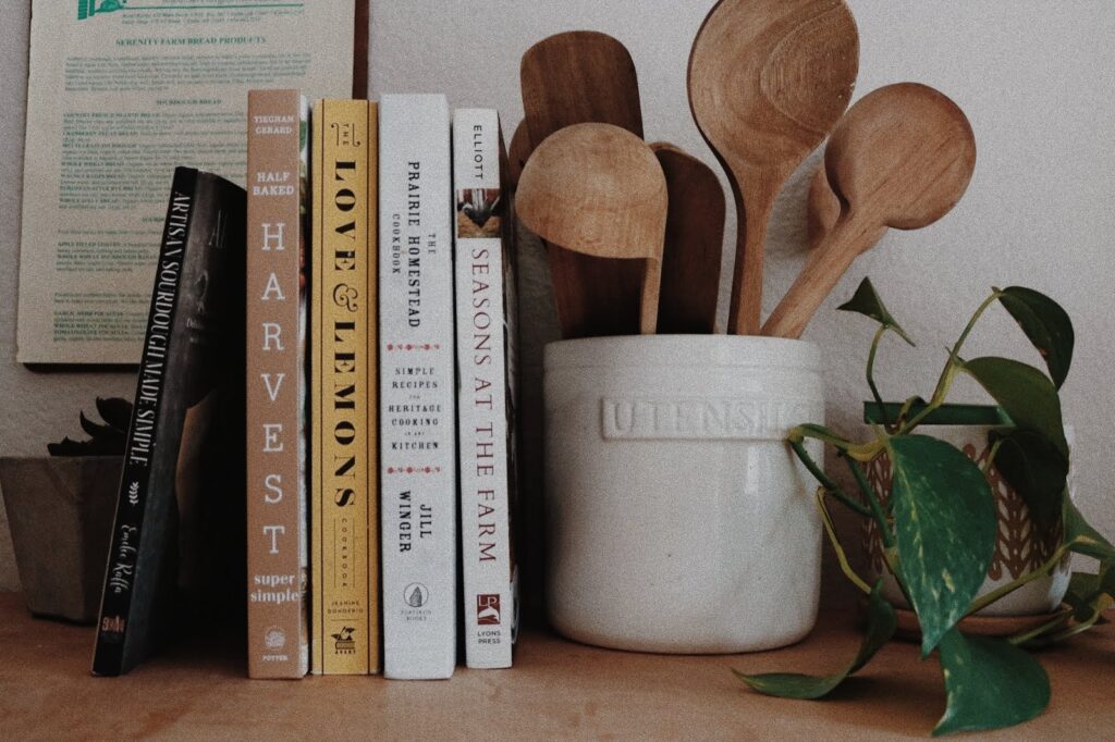 kitchen space with every day cookbooks next to a jar of wooden spoons